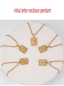 Vista detallada de cinco collares con colgante de letra inicial en acero chapado en oro