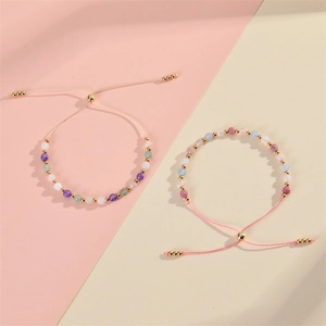 Gros plan de bracelets tissés réglables avec pierres naturelles et perles dorées