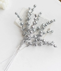 Close-up of silver sequin Christmas berry picks on white stems for festive decoration