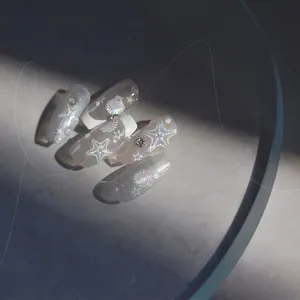 Macro detail of ocean-themed seashell nail art stickers with holographic glitter and rhinestones