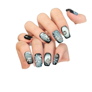 Handmade navy blue snowflake press-on nails with shimmering cat-eye and rhinestone design