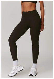 Macro shot of high-waist yoga leggings showing matte black fabric and seamless compression