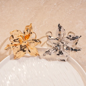 Metallic wrinkled flower open bangles in gold and silver finish on ceramic tray