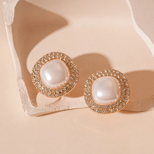 Détail macro de boucles d'oreilles perles carrées rétro avec strass et monture dorée