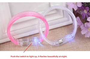 Detail view of pink and white LED glowing bracelets showing the integrated power switch