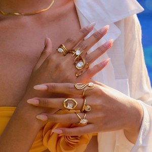 Detailed view of layered 18K gold plated titanium rings and zircon necklace set