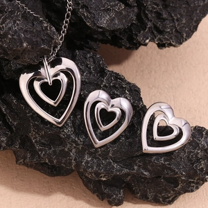 Detailed view of silver stainless steel jewelry set featuring hollow heart necklace and earrings