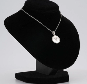 Detail of silver stainless steel shell necklace with letter Y pendant on black mannequin