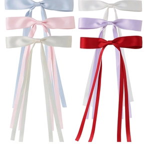 Detailed view of colorful satin ribbon bow hair clips with long streamers in five soft tones