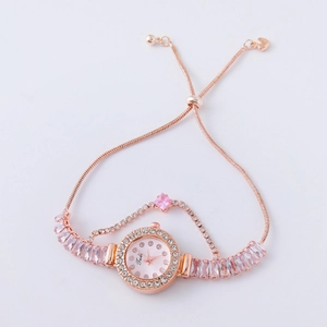 Detail of rose gold ladies watch featuring pink round dial and crystal studded bracelet