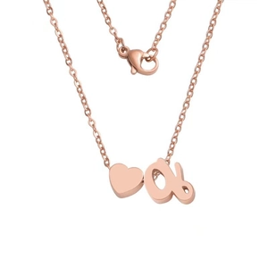 Macro view of rose gold heart and letter 'a' pendants on a fine link chain necklace