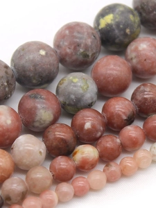 Macro shot of assorted natural plum blossom jade round beads in various earthy colors