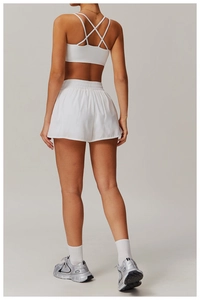 Détail arrière d'une brassière de sport blanche à bretelles croisées et short de yoga