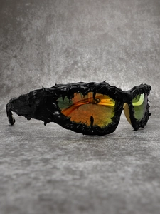 Detail of avant-garde spike frames and orange-green gradient polarized lenses