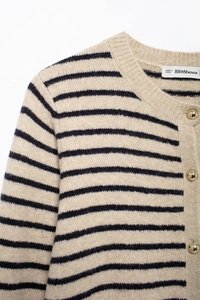 Detail of striped knit cardigan collar with textured fabric and golden metal buttons