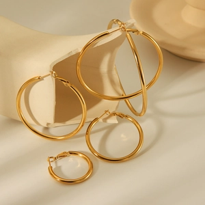 Elegant 18K gold plated stainless steel hoop earrings in four sizes on white ceramic