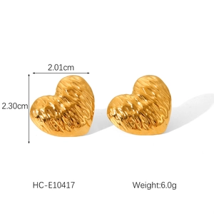 Detailed view of gold heart earrings featuring unique hammered texture and measurements