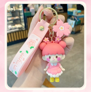 Close-up of pink Sakura girl keychain with floral pendant and branded wrist strap