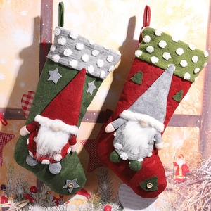 Calze di Natale festose con gnomi di peluche, sacchetti regalo in velluto rosso e verde.