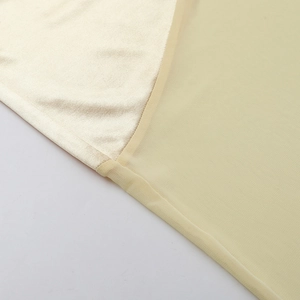 Macro detail of champagne satin and fine mesh splicing on a slim elegant dress