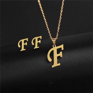Detailed view of gold letter F pendant necklace and matching stud earrings set