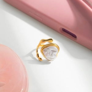 Bague dorée au design épuré avec perle en forme de cœur et texture métallique