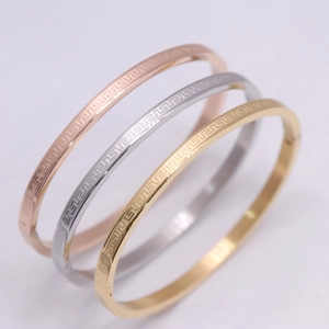Detailed view of three-color Greek key pattern bracelets in gold, silver, and rose gold