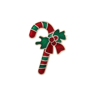 Cute Christmas candy cane brooch with red green enamel and gold bow on white background