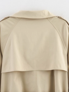 Close-up of khaki trench coat back detail showing smooth woven fabric and classic tailoring