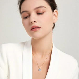 Minimalist silver necklace with round moissanite pendant worn by a model in soft light