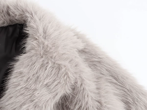 Detail of grey long faux fur collar with premium black silk lining and soft texture
