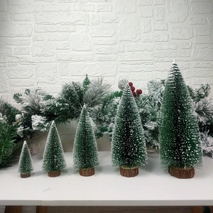 Mini green Christmas trees with snow flocked branches and natural wood bases