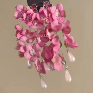 Detailed view of pink fabric floral drop earrings with elegant white pearl tassels