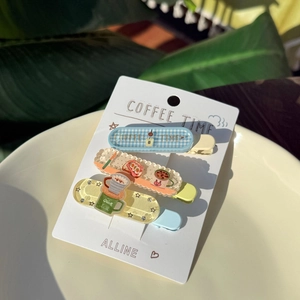 Detailed close-up of acrylic coffee theme hair clips in blue, beige and yellow colors
