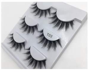 Detail view of 5 pairs of thick curly black false eyelashes in a white T03 display tray
