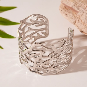 Detailed view of silver open cuff bracelet featuring an intricate coral branch texture