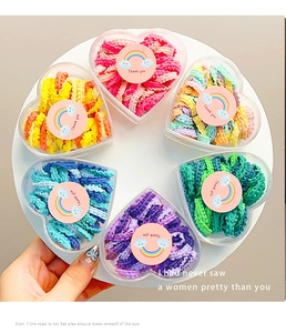Detail of candy-colored ruffled hair ties in heart-shaped gift boxes for little girls