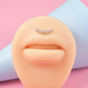 Gros plan détaillé d'un piercing à lèvre incurvé avec 7 zircons sur un modèle en silicone