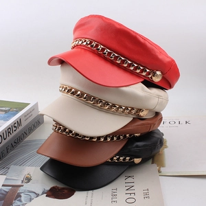 Flat top PU leather baker boy hats in red, beige, brown, and black with gold chain detail