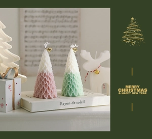 Detail of Christmas tree shaped candles with layered leaf texture in pink and green colors
