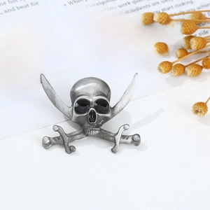 Macro view of vintage silver pirate skull and crossbones brooch with antique finish