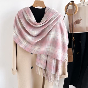 Detail of pink and white plaid scarf with fringe on a wooden hanger with aesthetic decor