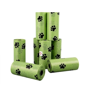 Detail of green biodegradable dog poop bags featuring black paw prints in an 8-roll set
