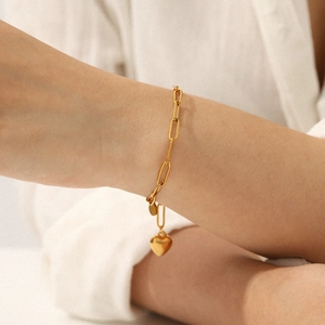 18K vergoldetes Edelstahl-Herzanhänger-Armband am Handgelenk eines Modells getragen