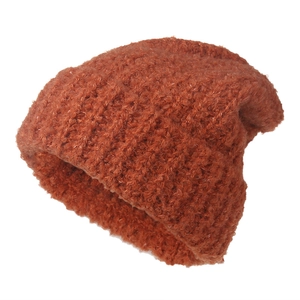 Detail of orange boucle knit beanie showing thick textured wool and warm winter fabric