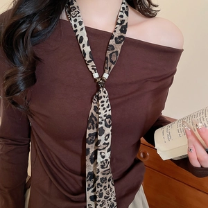 Close-up of leopard print chiffon neck scarf with metal buckle on brown off-shoulder top