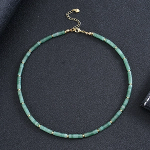 Detail of green beaded necklace with gold spacers and heart pendant clasp