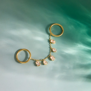 Bague double en acier inoxydable doré avec pampilles en zircone sur fond d'eau