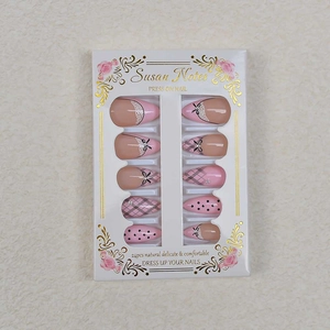 Detailansicht der Mandelnägel mit rosa Spitze, schwarzen Schleifen und Karomuster