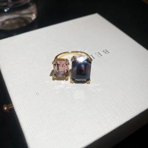 Macro shot of geometric open ring with large pink and deep blue rectangular zircon crystals